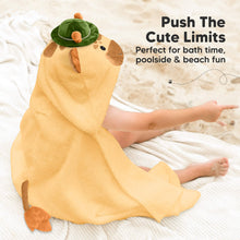 Load image into Gallery viewer, Child wearing a playpal hooded towel , sitting on a white blanket.