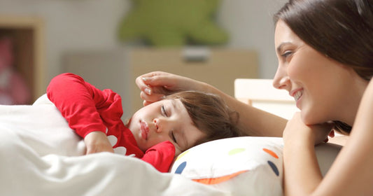 Mother watching over her baby sleeping peacefully in a toddler bed, creating a safe and comforting bedroom environment that supports healthy sleep and nighttime security.