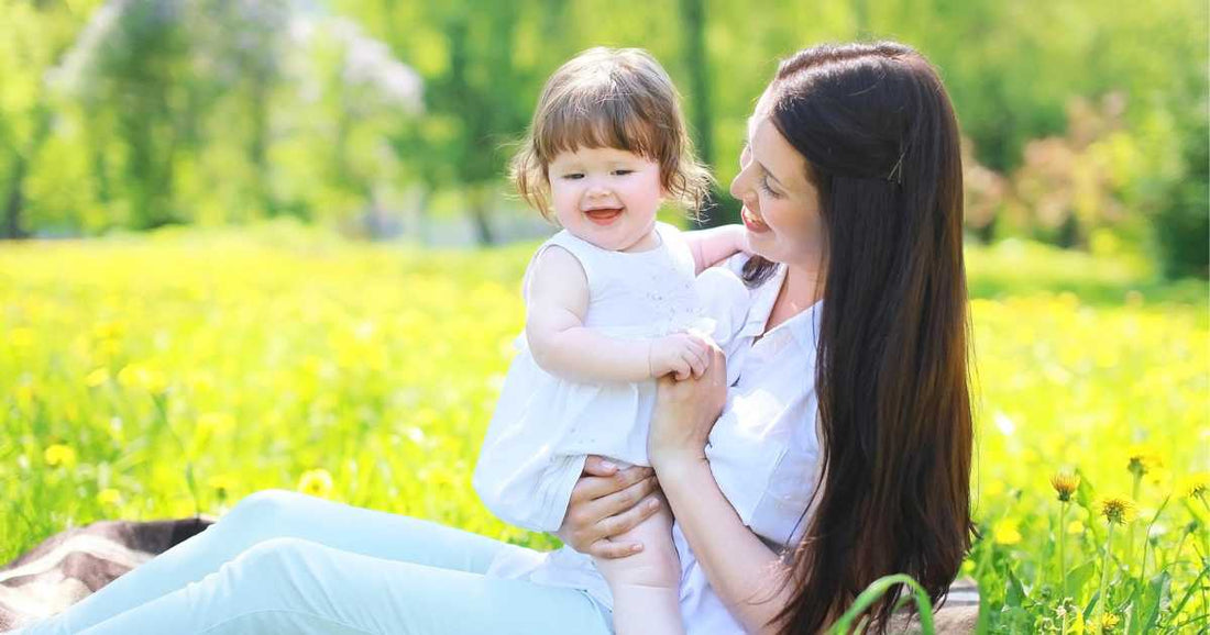 Mother bonding with her baby in a sunny park while enjoying a peaceful outdoor moment together.