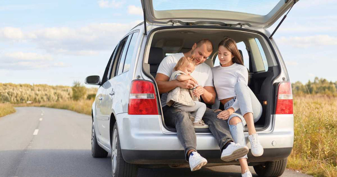 Family enjoying a summer road trip together in the back of the car.