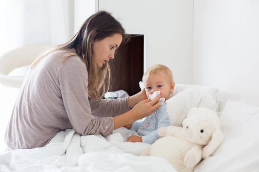 Mother caring for her congested, cold-stricken baby in cozy morning pajamas.